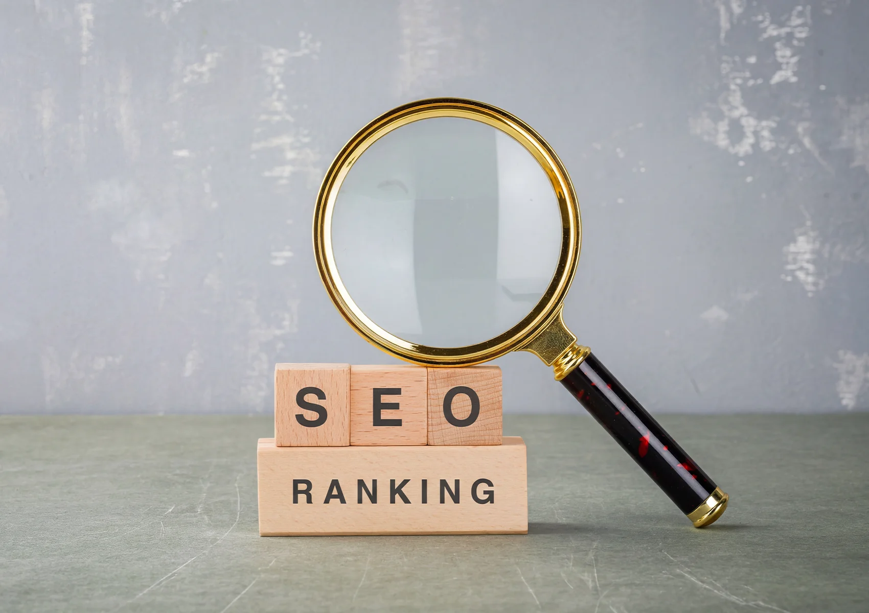 Magnifying glass over SEO ranking blocks representing strategies to improve search engine ranking and online visibility.